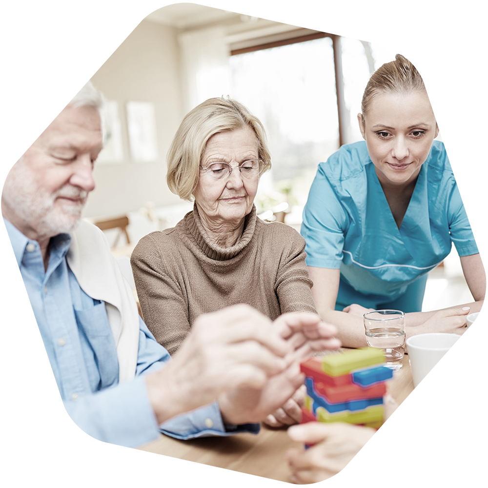 Elders playing a game while a care professional watches