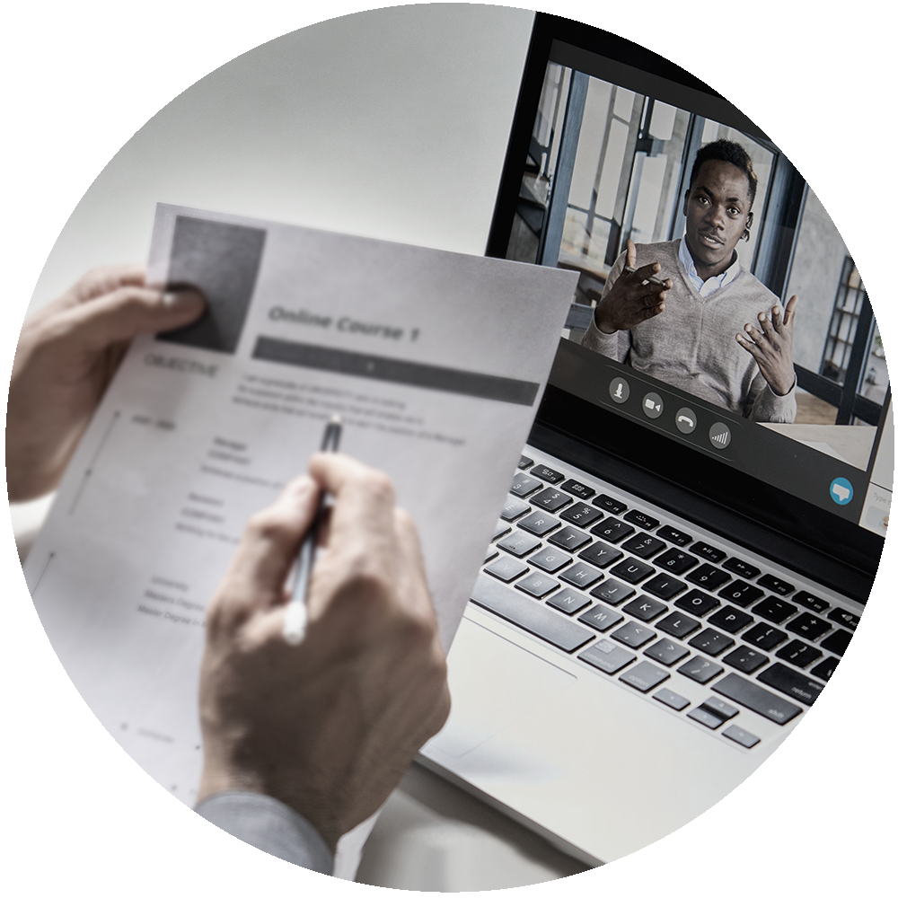 Person viewing a virtual session while reviewing a document.