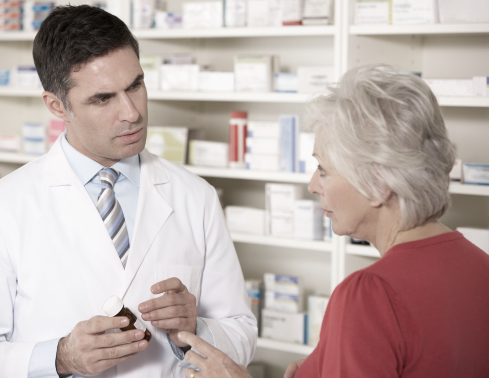 Pharmacist talks to older woman about prescription