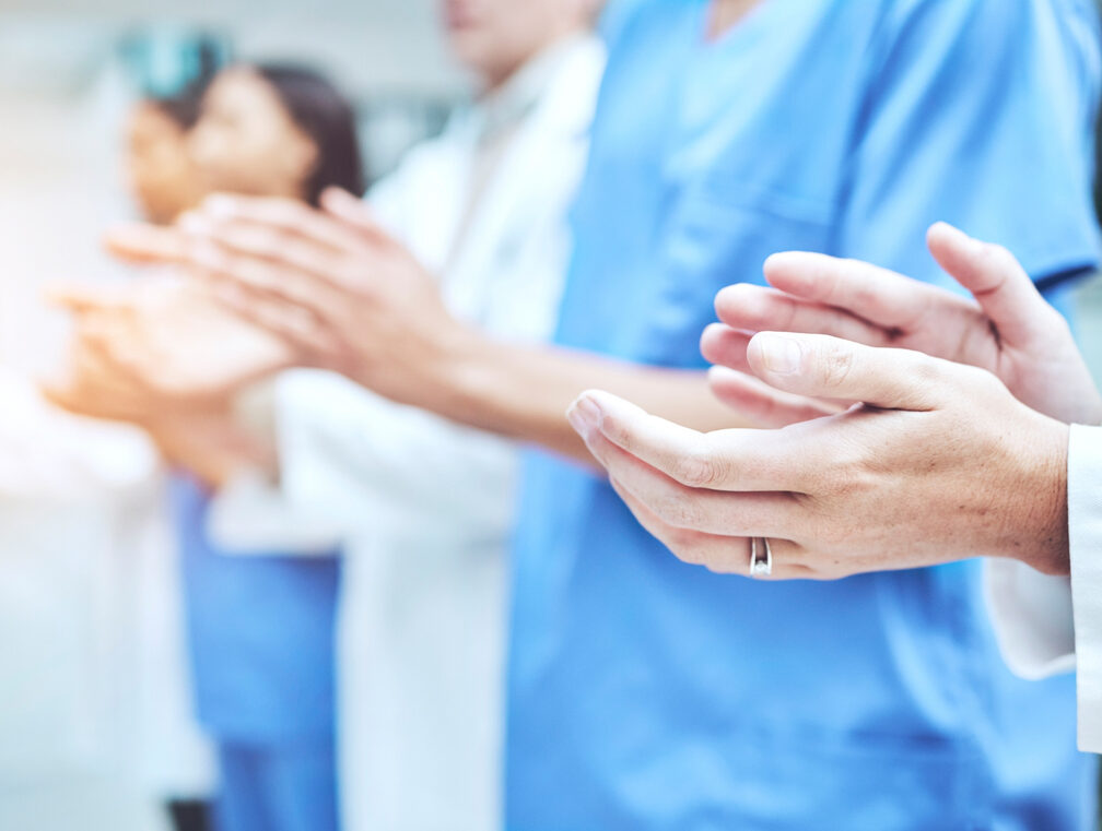 Clapping hands, celebration and team of doctors in the hospital with success in teamwork or collaboration. Solidarity, professional and group of healthcare workers with applause in a medical clinic.